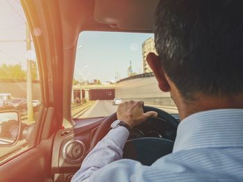 Rear view of man sitting in car