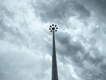 Low angle view of floodlight against cloudy sky