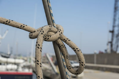 Close-up of rope tied on bollard against sky