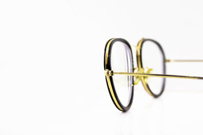 Close-up of eyeglasses on table against white background