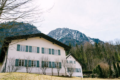 House and trees against sky during winter
