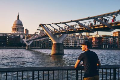 Rear view of man standing on railing