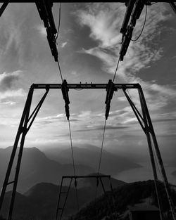 Low angle view of silhouette swing against sky
