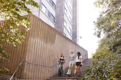 View of three young women walking down stairs