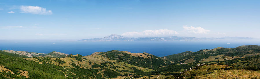 Scenic view of sea and mountains against sky