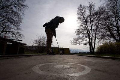 Low section of man skateboarding on road