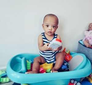 Portrait of cute baby boy sitting in toy