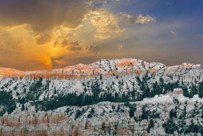 Scenic view of snowcapped mountains against sky during sunset