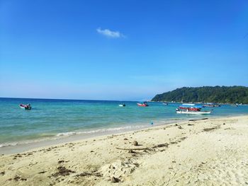 Scenic view of beach against blue sky