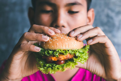 Close-up of boy eating burger