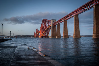 Golden gate bridge over river against cloudy sky