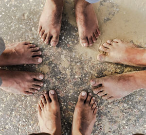 Low section of friends standing at beach