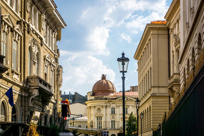 Cathedral and residential buildings against cloudy sky in city