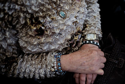 Midsection of woman wearing evil eye beads bracelet