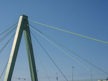 Low angle view of suspension bridge against clear blue sky