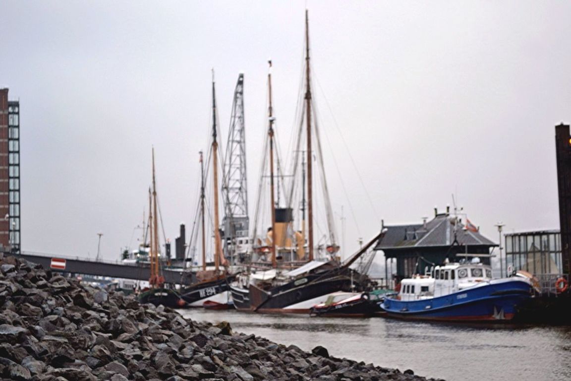 nautical vessel, transportation, mode of transport, moored, boat, water, harbor, mast, clear sky, built structure, copy space, sailboat, commercial dock, crane - construction machinery, river, architecture, construction site, travel, day, development