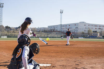 Female batter hitting the ball during a baseball game