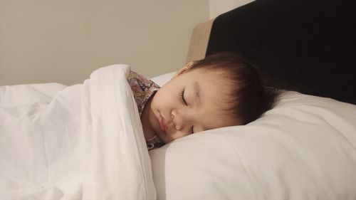 Portrait of child sleeping on bed