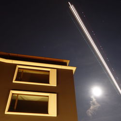 Low angle view of illuminated building against sky at night