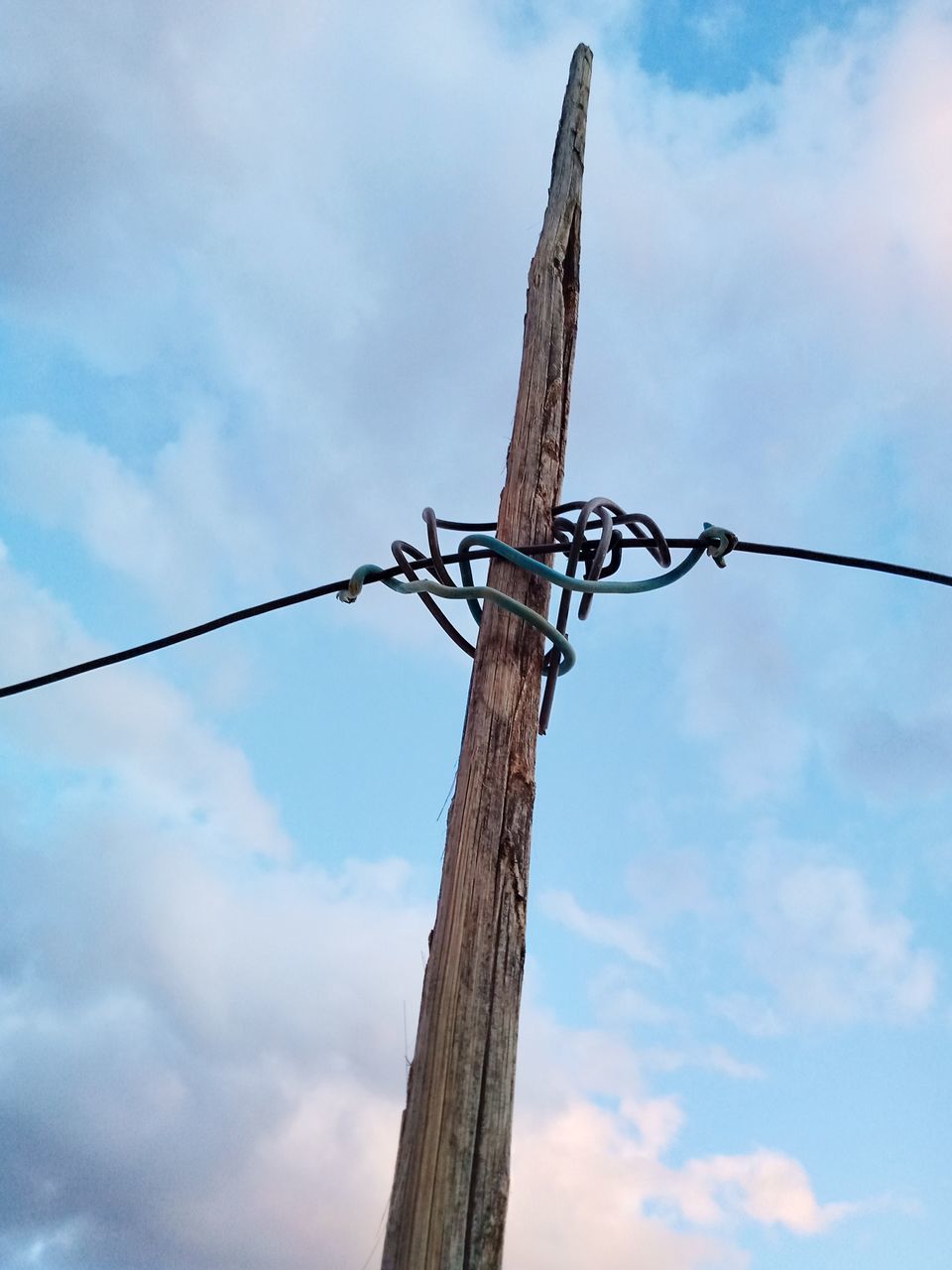 LOW ANGLE VIEW OF BARBED WIRE ON POLE AGAINST SKY