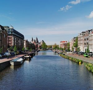 River amidst buildings in city against sky