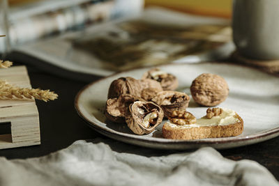 Bread toast with butter and open nuts on a plate in a cozy wood table