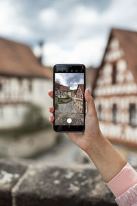 Midsection of person photographing with mobile phone