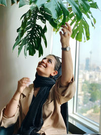 Portrait of young woman holding camera