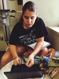 High angle view of teenager looking at laptop while sitting at home