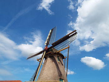 Low angle view of windmill against cloudy sky