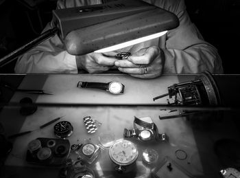 Midsection of man repairing watch