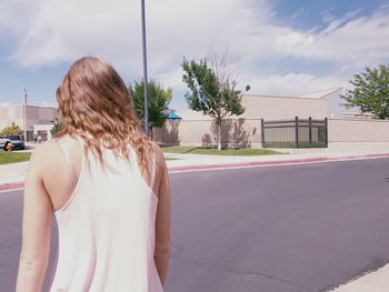 Rear view of woman standing in front of building