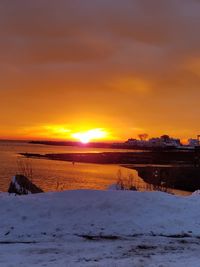 Scenic view of sea against orange sky during sunset