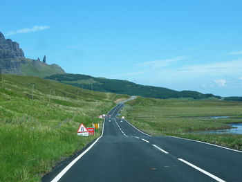 Scenic view of road by mountain against sky