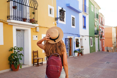 Happy tourist girl visiting the colorful spanish village villajoyosa, alicante, spain.