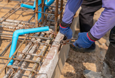 Workers tie steel wires to the ground to pour mortar in construction site.