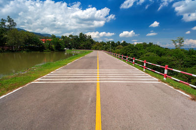 Road by trees against sky