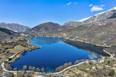 Scenic view of lake and mountains against blue sky