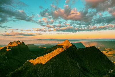 Scenic view of mountain against cloudy sky during sunset