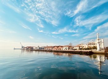 Reflection of buildings in sea against sky