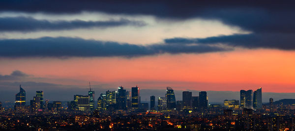 View of cityscape against cloudy sky during sunset