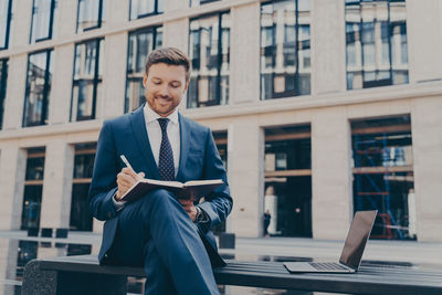 Portrait of young man standing in city