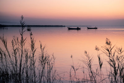 Two boats at valencia's albufera sunset against the light