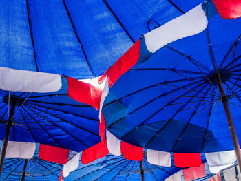 Low angle view of flags against blue sky