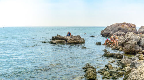 Rock formations on sea shore against sky