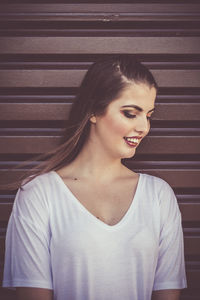 Young woman looking down against wall