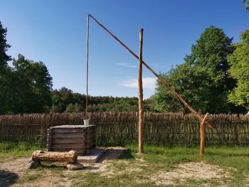 Wooden fence on field against clear sky