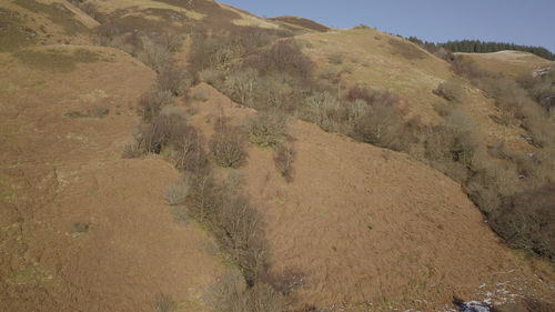 Scenic view of land and mountains against sky