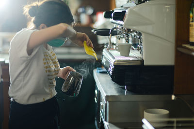 Hands of young adult caucasian female barista at work preparing