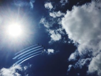 Low angle view of airplane flying against sky on sunny day